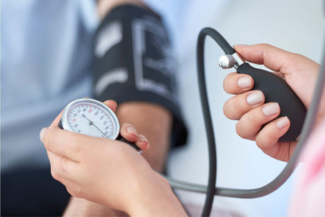 Ärztin misst Blutdruck bei Patienten